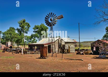 Casa fatta di ferro ondulato, vecchie auto arrugginite e un mulino a vento nella città fantasma di Gwalia nel Great Victoria Desert, shire di Leonora, Australia Occidentale Foto Stock