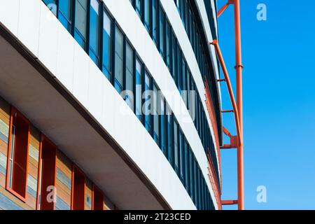La facciata bianca della casa con dettagli in acciaio rosso è sotto il cielo blu. Sfondo astratto dell'architettura moderna Foto Stock
