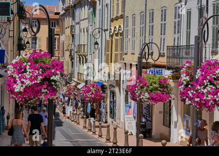 Affascinante strada europea ombreggiata con fiori colorati e l'architettura storica nella città vecchia di Antibes sulla Costa Azzurra Foto Stock