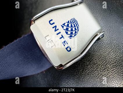 Chicago, US, 5 ottobre 2023: Dettaglio della fibbia della cintura di sicurezza con il logo di United Airlines su un posto vuoto. Una grande compagnia aerea americana. Illustrativ Foto Stock