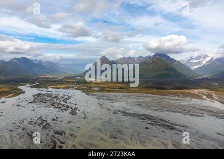 Una vista aerea di un fiume intrecciato che scorre attraverso una valle circondata da montagne, che mostra la bellezza naturale e il paesaggio dinamico della regione. Foto Stock