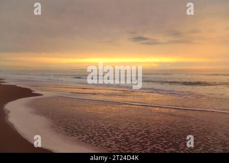 Tramonto dorato sulla spiaggia e cielo nuvoloso. Splendido paesaggio marino, spazio di copia per il testo Foto Stock