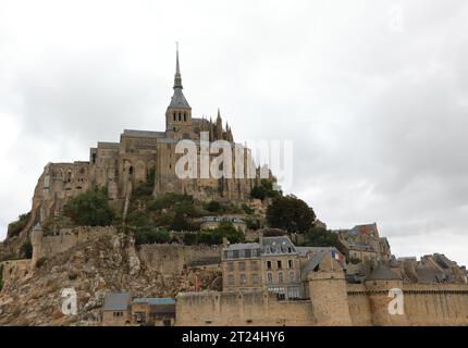 Famoso monastero di Mont Saint Michel con la chiesa abbaziale costruita sopra la collina durante la bassa marea in Francia, in Normandia Foto Stock