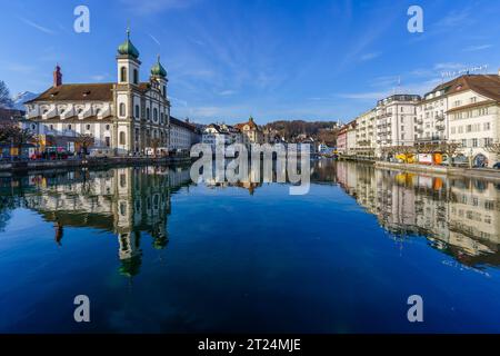 Lucerna, Svizzera - 22 febbraio 2023: Vista della chiesa gesuita di San Francesco Cavier e del fiume Reuss, con altri edifici, locali e visitatori Foto Stock