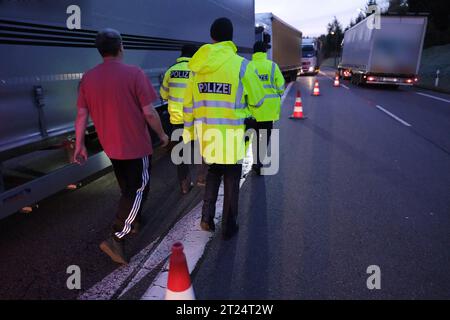 Reitzenhain, Germania. 17 ottobre 2023. Gli agenti di polizia federale controllano un camion vicino al confine tedesco-ceco. La decisione del ministro degli interni tedesco Faeser (SPD) di lunedì 16 ottobre 2023 aveva temporaneamente introdotto controlli alle frontiere interne. Faeser aveva annunciato di aver notificato alla Commissione europea i controlli stazionari per le frontiere con Polonia, Repubblica ceca e Svizzera. Credito: Sebastian Willnow/dpa/Alamy Live News Foto Stock