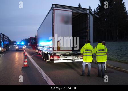 Reitzenhain, Germania. 17 ottobre 2023. Gli agenti di polizia federale controllano un camion vicino al confine tedesco-ceco. La decisione del ministro degli interni tedesco Faeser (SPD) di lunedì 16 ottobre 2023 aveva temporaneamente introdotto controlli alle frontiere interne. Faeser aveva annunciato di aver notificato alla Commissione europea i controlli stazionari per le frontiere con Polonia, Repubblica ceca e Svizzera. Credito: Sebastian Willnow/dpa - ATTENZIONE: Parti delle immagini sono state pixellate per motivi legali/dpa/Alamy Live News Foto Stock