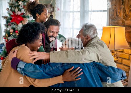 Allegra famiglia multietnica che si diverte festeggiando il Natale insieme a casa. Foto Stock