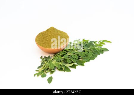 Polvere di Moringa con foglie su sfondo bianco isolato Foto Stock