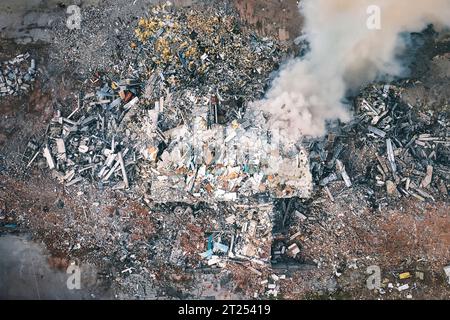 Vista dall'alto dell'edificio distrutto. Vista aerea delle rovine. fumo dalla vista aerea dell'edificio distrutto. Vista dall'alto e ripresa dal drone. Foto Stock