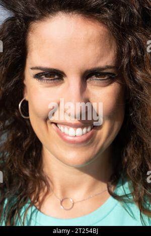 Ritratto ravvicinato estremo di una giovane bruna sorridente, occhi marroni e denti perfetti, guardando la fotocamera sorridente. Trattamenti di bellezza per il viso Foto Stock