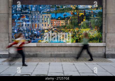 Londra, Regno Unito. 17 ottobre 2023. I membri del personale passano (parte di) il tranquillo e incantevole, un'installazione all'aperto di opere d'arte digitali e stampate che immaginano un futuro in cui il circostante Borough of Westminster è stato ripopolato, che viene svelato lungo il recentemente pedonale Strand Aldwych. Presentato dallo studio di design Superflux in collaborazione con King's College London, le opere possono essere viste dal pubblico fino alla primavera del 2024. Crediti: Stephen Chung / Alamy Live News Foto Stock