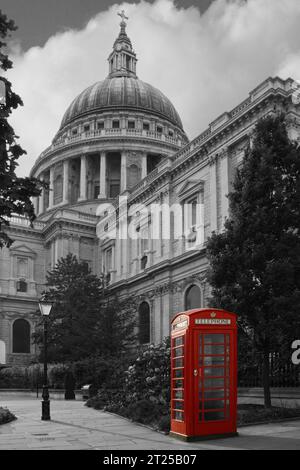 Cabina telefonica di colore rosso isolata di fronte alla Cattedrale di Saint Paul a Londra su un ambiente bianco e nero. Foto Stock