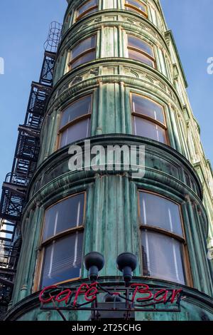 SAN FRANCISCO, USA - 22 aprile 2023: Da sotto l'esterno del vecchio edificio Sentinel con scale esterne di colore verde, pareti in vetro e luci di zoom accese Foto Stock