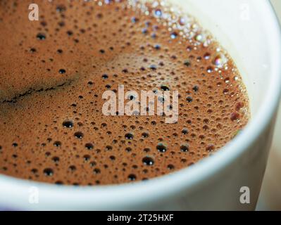 Macro immagine del caffè in tazza, con molte bolle in alto, vista ravvicinata Foto Stock