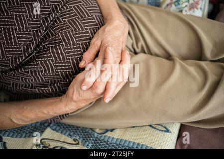 Mani dell'anziano. Punto forte delle mani di una donna anziana sulla pancia sotto forma di riposo. Momenti di relax sul divano, pausa sonnellino. Primo piano Foto Stock