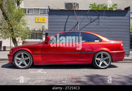 Almaty, Kazakistan - 25 agosto 2023: Il lato della BMW 3 Series coupé è arancione. Parcheggio in strada Foto Stock