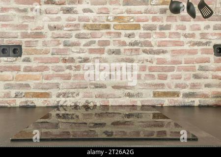 un muro di mattoni con alcune luci e un orologio appeso al soffitto nella stanza è fatto di mattoni Foto Stock