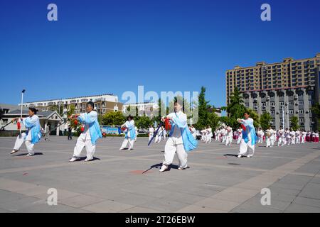 Contea di Luannan, Cina - 22 agosto 2023: Lo spettacolo di Tai chi Sword viene eseguito su una piazza. Foto Stock