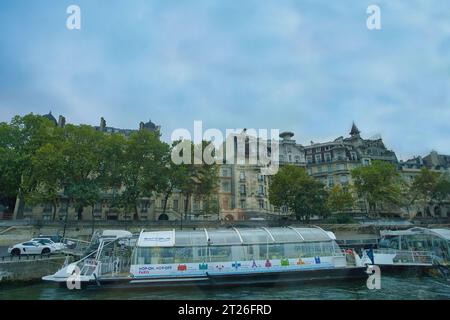 Francia, Parigi 25.08.2023 vista su Batobus e edificio Quai Anatole 27, da Bateaux Parisiens sul fiume Senna Foto Stock