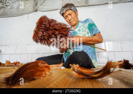 Contea di Luannan, Cina - 26 agosto 2023: L'artigiano sta facendo una piuma. Foto Stock