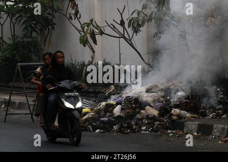 17 ottobre 2023, Yogyakarta, regione speciale di Yogyakarta, Indonesia: I motociclisti passano per bruciare i rifiuti sul lato della strada a Yogyakarta. (Immagine di credito: © Angga Budhiyanto/ZUMA Press Wire) SOLO USO EDITORIALE! Non per USO commerciale! Foto Stock