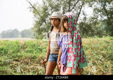 Ragazze avventuriere multietniche in piedi nella natura selvaggia guardando la macchina fotografica - concetto di amanti dell'ambiente e della natura Foto Stock