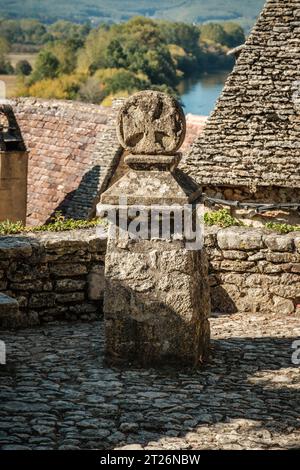 La croce occitana nella piazza Cafourche a Beynac-et-Cazenac nella regione francese della Dordogna segna il punto in cui sorgeva la chiesa di San Jaques Foto Stock