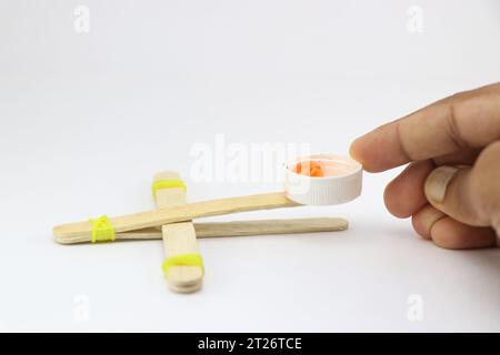 Modello a bastoncino di una catapulta realizzato con materiali riciclati. I piccoli mestieri costruiti a casa mostrano il concetto creativo Foto Stock