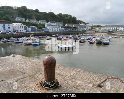 Barche da pesca colorate che si trovano sulla sabbia con la bassa marea nel porto di Porthleven, in Cornovaglia, Inghilterra Foto Stock