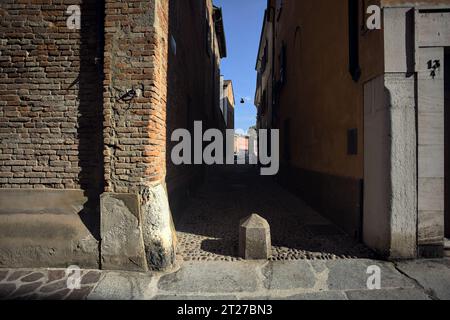 Angolo di una strada con un vicolo acciottolato in una città italiana Foto Stock