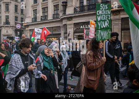 I manifestanti pro-palestinesi gridano canti e tengono striscioni a marzo attraverso il centro di Londra dalla BBC a Downing Street. Ottobre 2023. Foto Stock