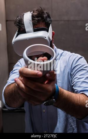 Giovane che gioca con il visore VR all-in-one Meta quest 2 durante ZGamer, un festival di videogiochi, intrattenimento digitale, giochi da tavolo e YouTuber d Foto Stock