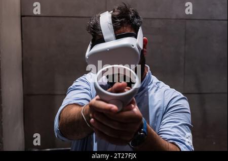 Giovane che gioca con il visore VR all-in-one Meta quest 2 durante ZGamer, un festival di videogiochi, intrattenimento digitale, giochi da tavolo e YouTuber d Foto Stock