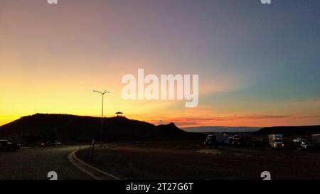 Un paesaggio tranquillo caratterizzato da una vasta catena montuosa con una collina in primo piano Foto Stock