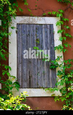 una vecchia finestra chiusa con una tapparella di legno Foto Stock
