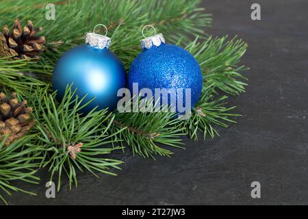 Decorazioni natalizie o di Capodanno, pallina natalizia su sfondo scuro, composizione festiva. Rami di pino con coni di pino, concetto invernale Foto Stock