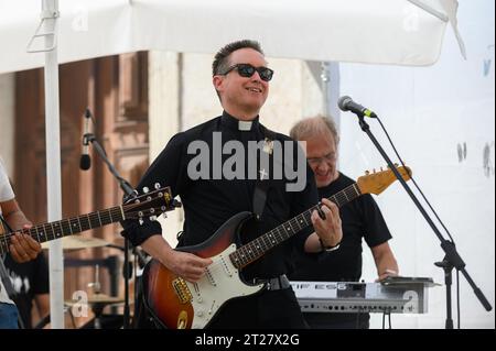 Una band, tra cui un prete cattolico, che tiene un concerto durante le Giornate mondiali della gioventù 2023 a Lisbona, Portogallo. Il concerto si è svolto vicino alla chiesa di St Roch. Foto Stock