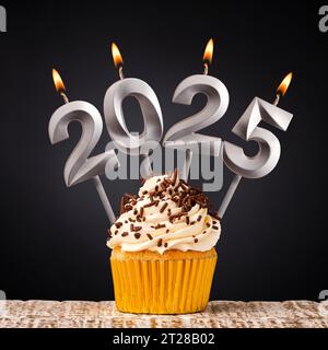 Felice anno nuovo 2025 - candele sotto forma di numeri brucianti su sfondo giallo Foto Stock