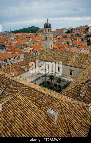 Vista dalla passeggiata delle mura della città del cortile e del campanile della chiesa francescana e del monastero nella città vecchia di Dubrovnik, nel sud della Croazia. Foto Stock