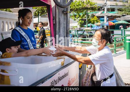 Bangkok, Thailandia. 14 ottobre 2023. Miss Thailand World 2023, Tharina Botes offre un pasto gratuito ai senzatetto con la Bangkok Community Help Foundation, presso la Trok Sake Community di Bangkok. Miss Thailand World 2023, Tharina Botes, patrimonio misto thailandese-sudafricano, si unì come volontario a una dispensa di pasti gratuiti per senzatetto e persone a basso reddito, organizzata dalla Bangkok Community Help Foundation, a Bangkok, Thailandia. Credito: SOPA Images Limited/Alamy Live News Foto Stock