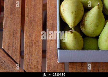 Pere in scatola di cartone su un tavolo di legno con vista dall'alto Foto Stock