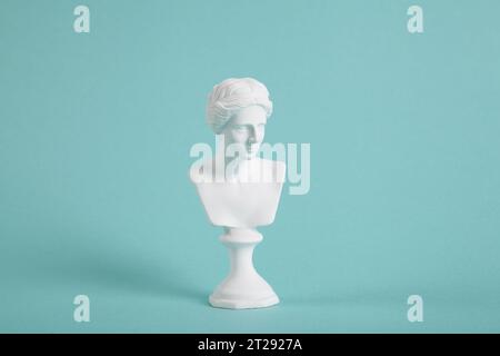 un busto di venere bianco su un vivace sfondo turchese. Un mix di classico e moderno. Fotografia minimalista e alla moda. Foto Stock