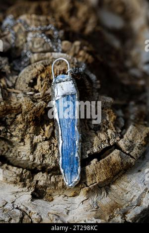 Ciondolo grezzo in cianite abbracciato dall'argento. Gemstone con un forte effetto calmante su tutto l'essere, dà tranquillità interiore e pace, un amplificatore di energia Foto Stock