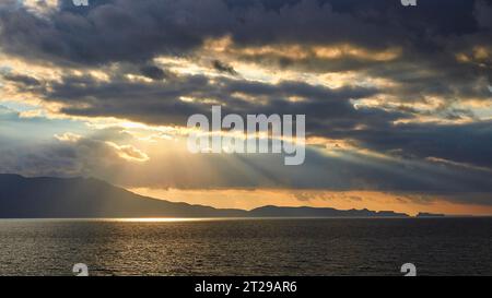 Tramonto spettacolare, cielo nuvoloso, penisola di Rodopou, raggi del sole che si infrangono tra le nuvole, raggio del sole sul mare, Creta Occidentale, provincia di Chania, Creta, Grecia Foto Stock