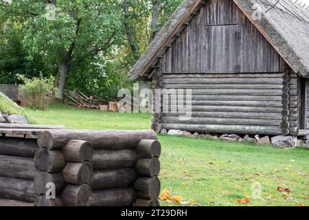 Una casa di legno con un frammento di un pozzo di legno davanti Foto Stock