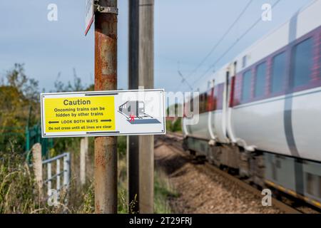 Attenzione, guardare in entrambe le direzioni, segnale di avvertimento al passaggio a livello sulla East Coast Mainline Railway. Foto Stock