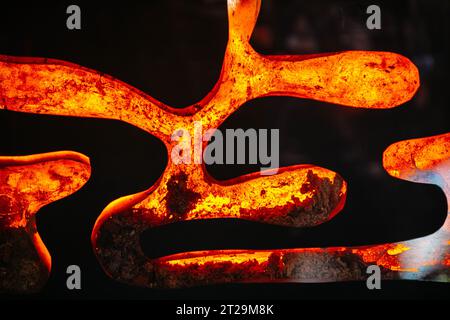 Sfondo astratto a cornice intera di metallo caldo rosso che forma figure curve e fiammeggianti al buio Foto Stock