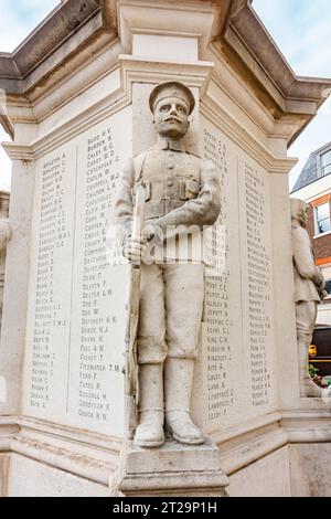 Una scultura di un soldato si trova in un angolo della base del monumento commemorativo di guerra che si trova in Market Square , Staines-upon-Thames, Surrey, Regno Unito Foto Stock