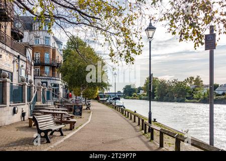 Una vista sul Tamigi a Staines-upon-Thames oltre lo Slug e il pub di lattuga con tavoli e panchine all'esterno. Foto Stock