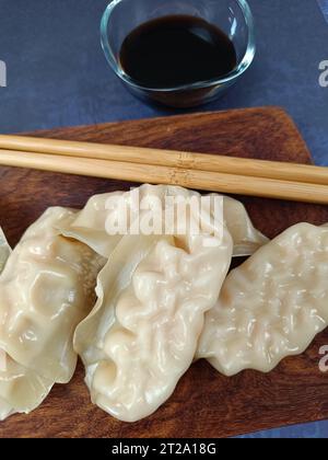 diversi gyoza in un piatto di legno, in primo piano Foto Stock